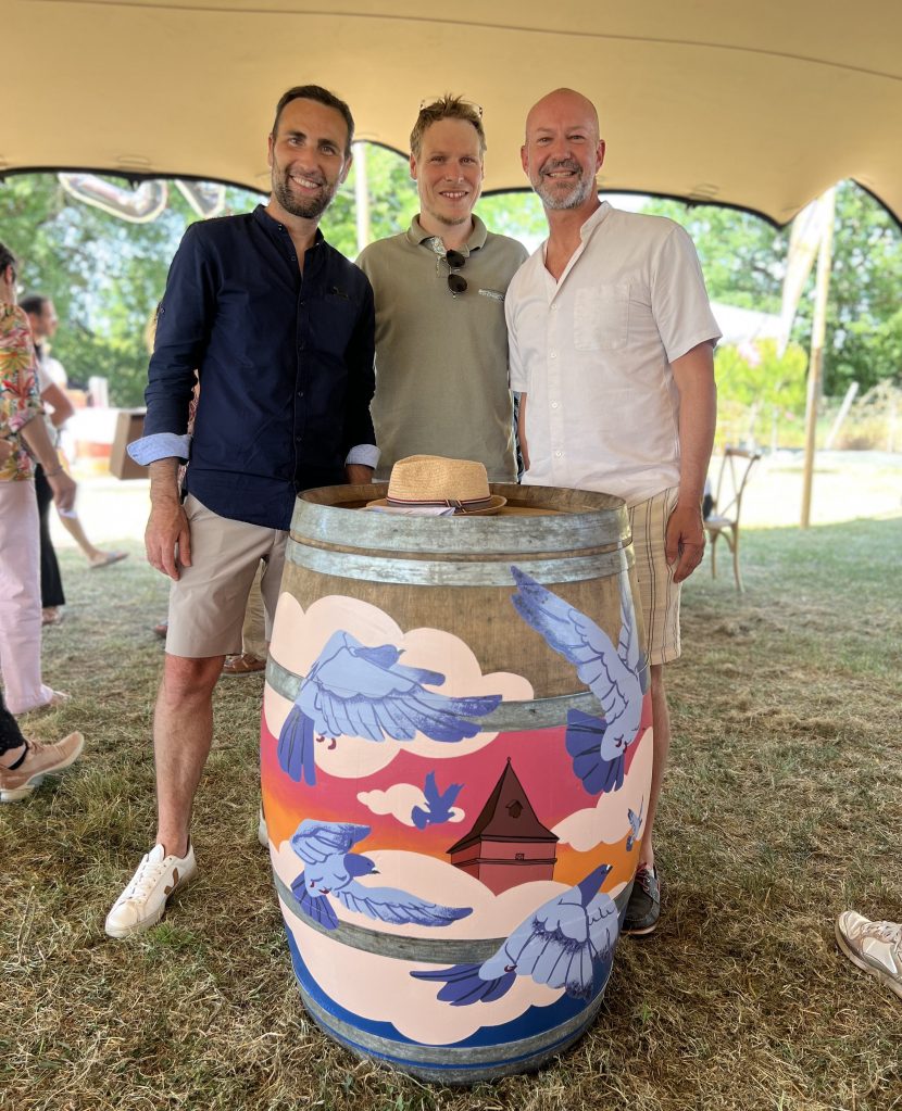 Paul Marnata, au centre, aux côtés des acheteurs de la barrique de vin personnalisée qu'il a peinte à la main, et qui représente un vol de pigeons autour du pigeonnier qui va être rénové grâce aux fonds gagnés lors de la vente aux enchères de la barrique.