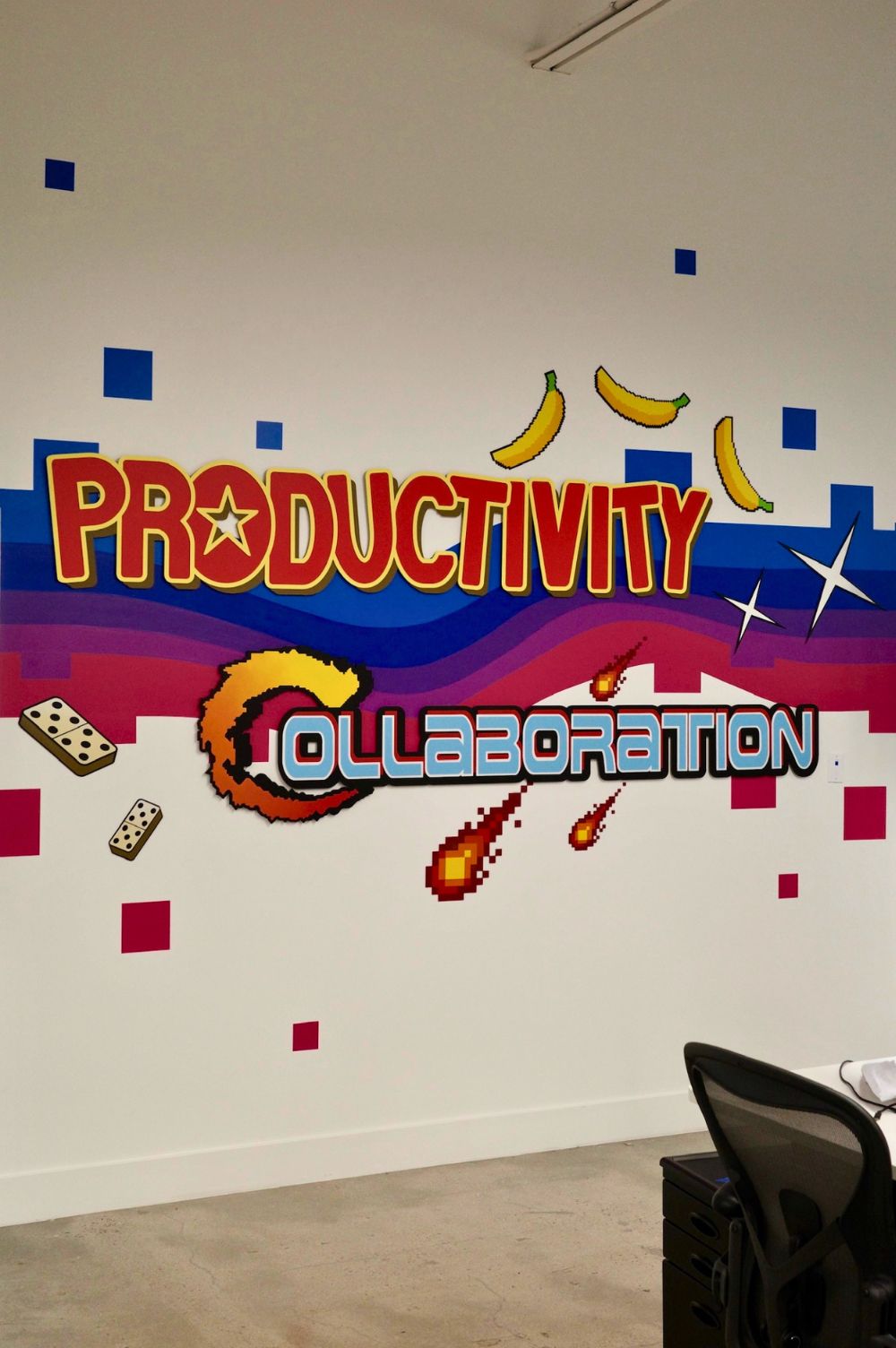les mots productivity et collaboration sur un mur décoré peint à la main.