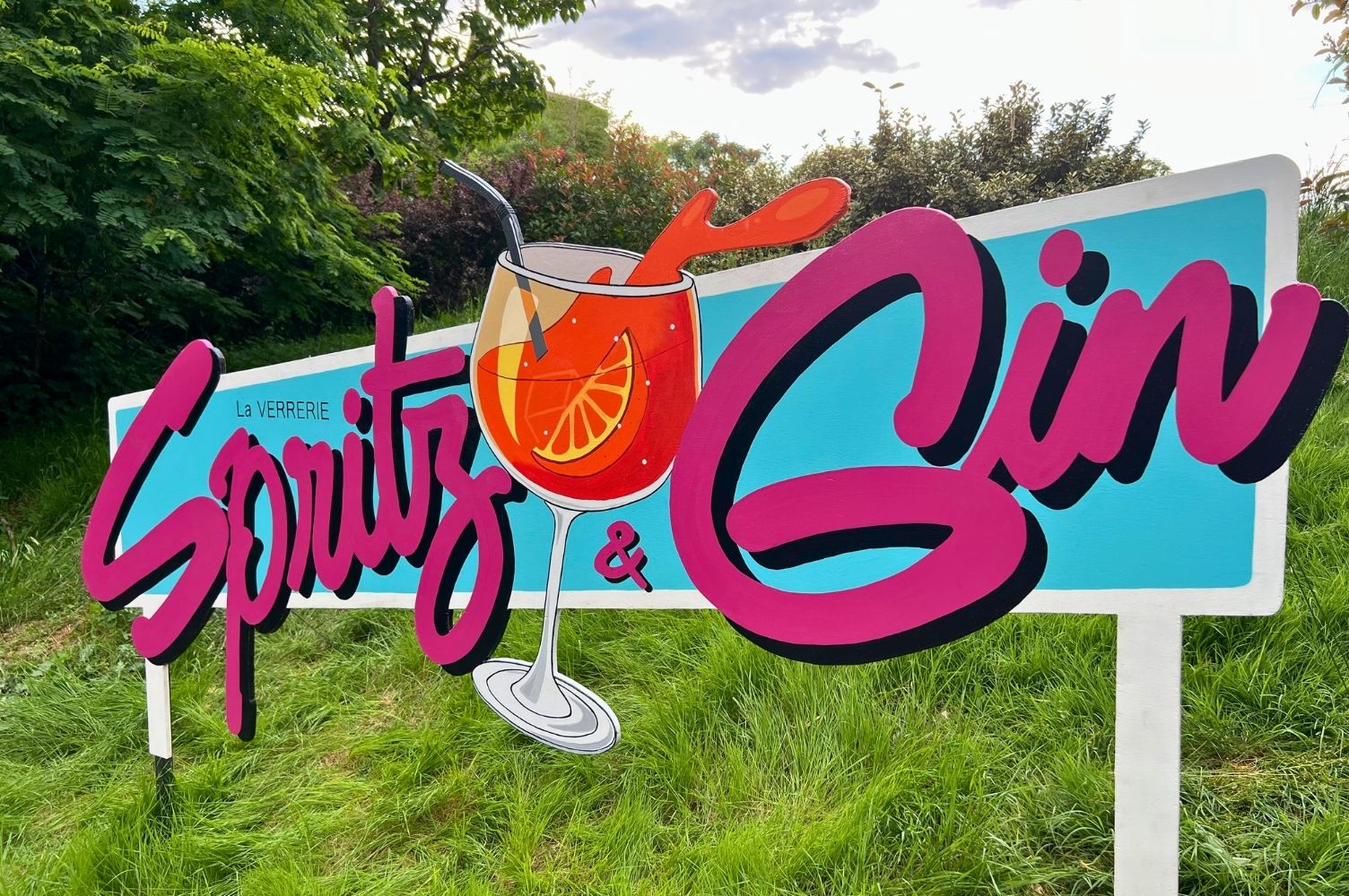 grande enseigne peinte représentant un cocktail spritz pour l'espace gin et spritz de l'hôtel restaurant la verrerie à Gaillac