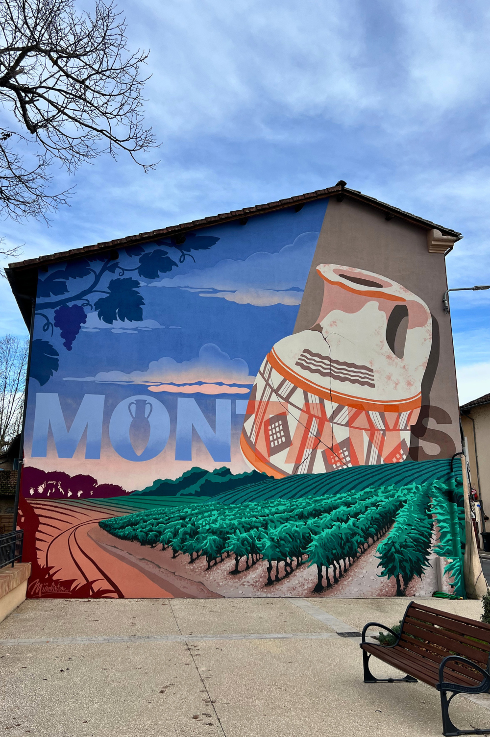 grande fresque murale avec pour inscription centrée dans la hauteur MONTANS avec une amphore et des vignes