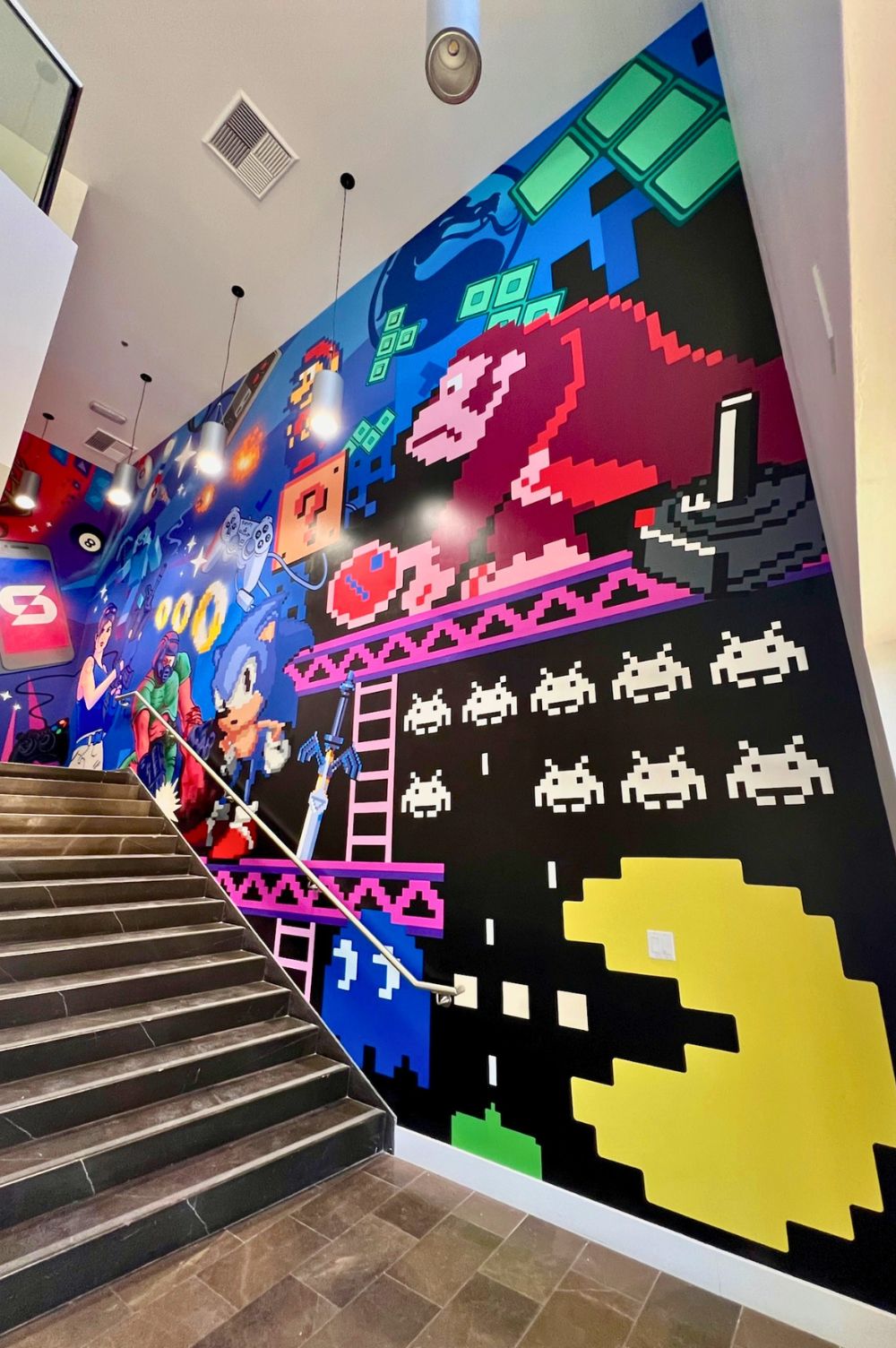 mur peint à la main représentant des jeux vidéos dont pacman en bas à droite.