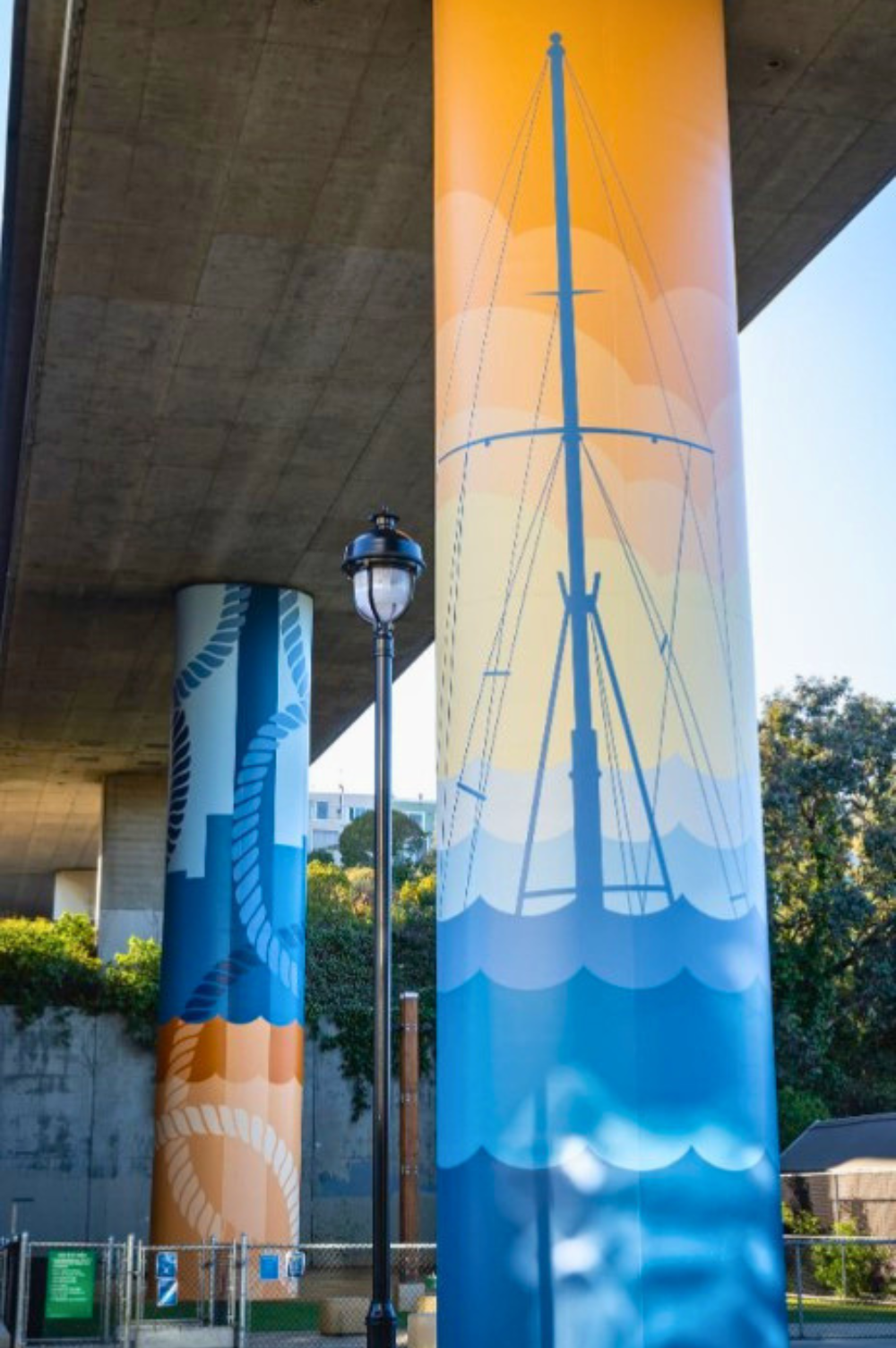 pilier d'autoroute peints avec un décor maritime, des bateaux et cordes d'amarrage.