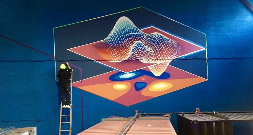 Paul peint la fresque murale du haut de son échelle à gauche